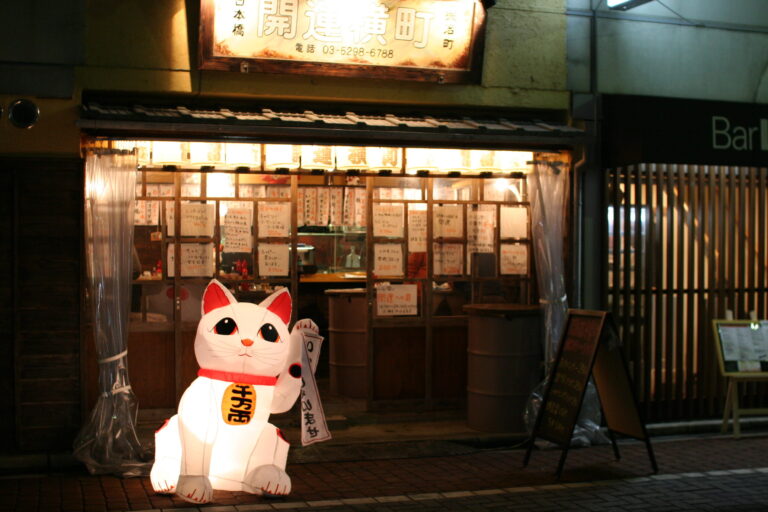 maneki_neko_in_front_of_a_tachinomi_stand_izakaya_in_tokyo